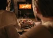 Un couple profite de la chaleur d'un poêle à bois bien allumé, parfait pour des soirées confortables après avoir utilisé la méthode du feu inversé.